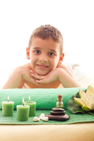 Lächelnder Junge auf dem Massagetisch liegend — Stockfoto