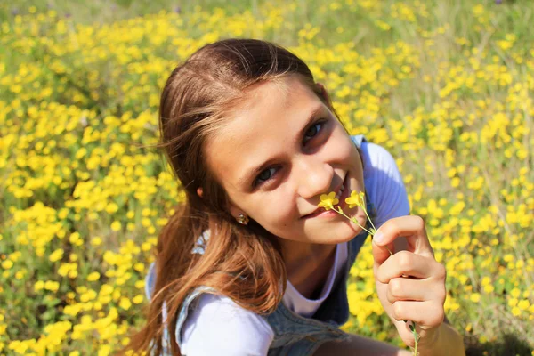 Meisje op de aard van een bloemrijke — Stockfoto