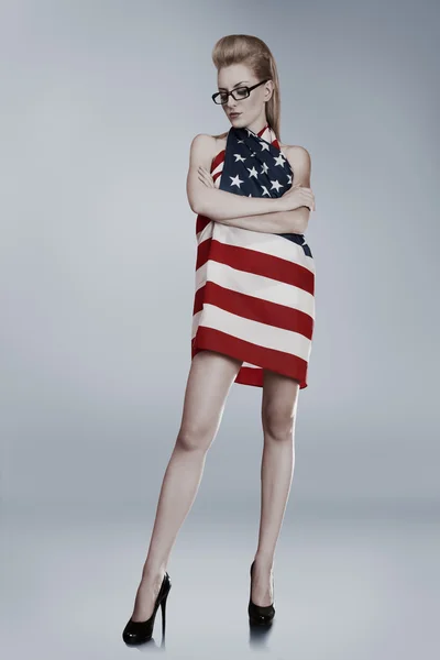 Junge Frau in amerikanische Flagge gehüllt lizenzfreie Stockfotos