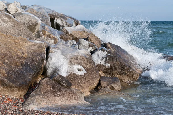 Isen täckte stenar på en strand i vinter — Stockfoto