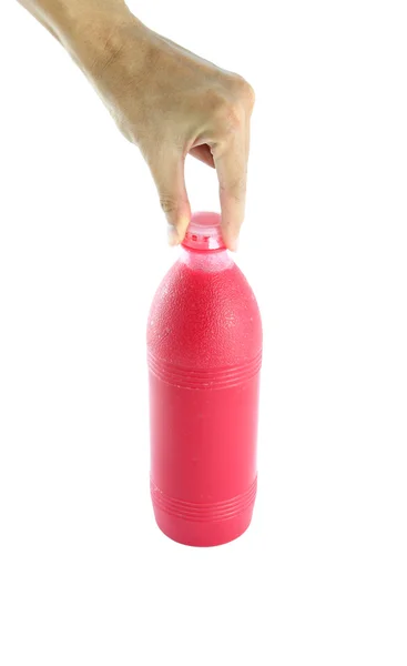 Červená láhev s vodou v sevření prstů ruky na bílém pozadí. — Stock fotografie