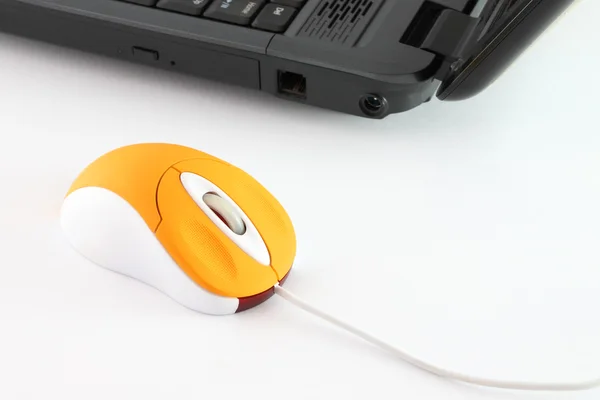 Naranja ratón de ordenador en el escritorio de trabajo . — Foto de Stock