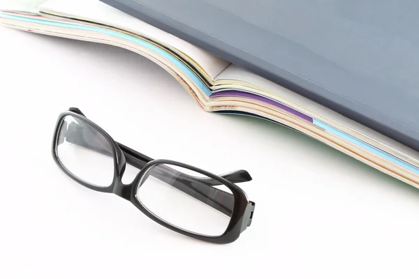 stock image Glasses in front of opened magazines.