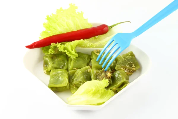 Blad van rijst meel dekking varkensvlees Thaise snack en blauwe vork. — Stockfoto