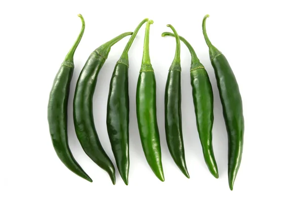 Řádek zelené chilli na bílém pozadí. — Stock fotografie
