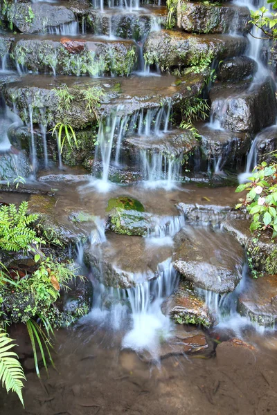 Schritt des kleinen Wasserfalls im öffentlichen Park. — Stockfoto