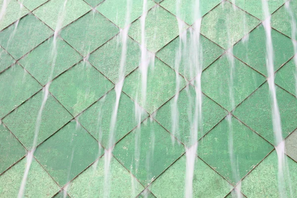 Caduta d'acqua sulla parete di piastrelle verdi . — Foto Stock