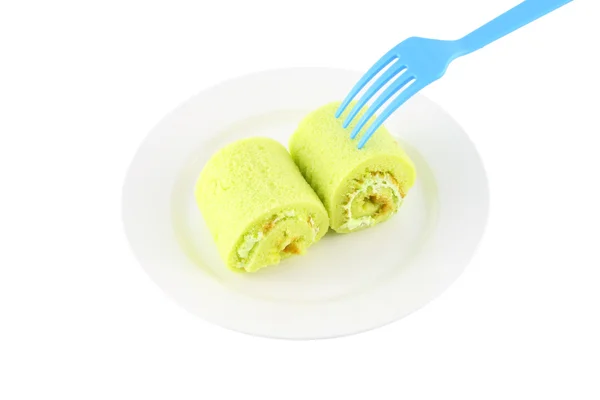 Zielona słodka roll ciasto na danie i niebieski widelec. — Zdjęcie stockowe