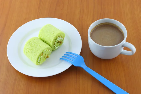 Zielona słodka roll ciasto i słodkie napoje na serverze czas. — Zdjęcie stockowe