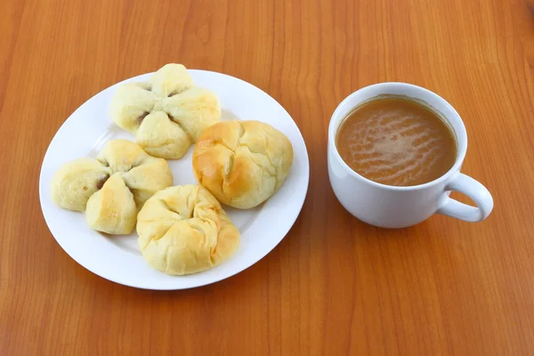 Pão doce e chá de creme no tempo de quebra . — Fotografia de Stock