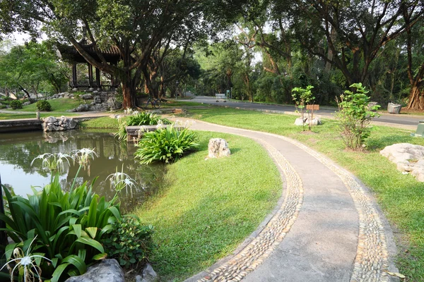 Ścieżka spacerem krzywej stronie staw ogród chiński. — Zdjęcie stockowe