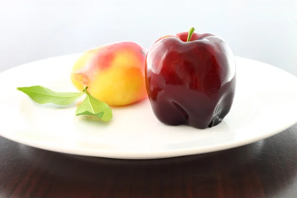 Deletable imitation fruits blur left one dessert on dish. — Stock Photo, Image