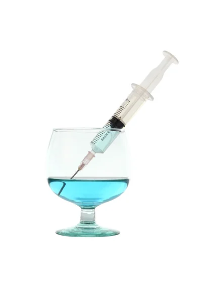 注射器吸在白色背景上的蓝色的液体从玻璃. — 图库照片