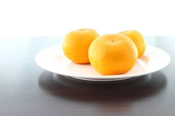 Três prato laranja na mesa de madeira . — Fotografia de Stock