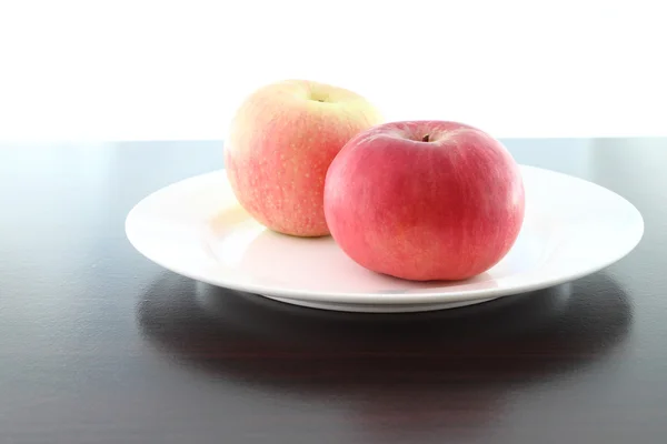 Fokus merah dekat apel piring di atas meja kayu . — Stok Foto