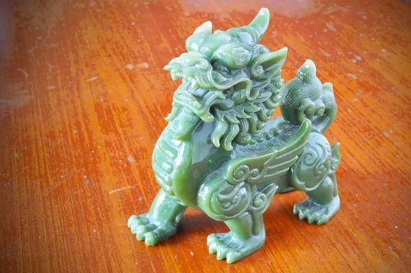 Jade animal sagrado chino (llamada en chino es PE-SIA) sobre fondo de madera Fotos De Stock