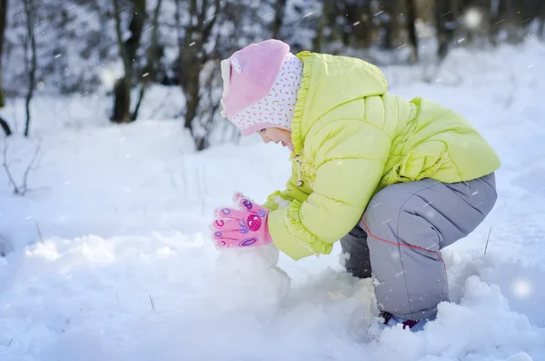 Gry dziewczyna ze śniegiem w parku — Zdjęcie stockowe