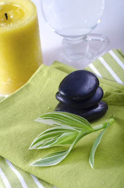 Pietre nere su asciugamano verde — Foto Stock