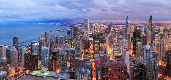 Chicago skyline panorama aerial view with skyscrapers over Lake Michigan with cloudy sky at dusk.