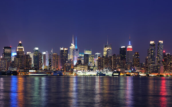 New York City Manhattan midtown skyline panorama at dusk with historical landmark skyscrapers over Hudson River viewed from New Jersey Weehawken waterfront.
