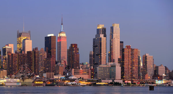 New York City Manhattan sunset panorama with historical skyscrapers over Hudson River with beautiful red color sunshine reflection viewed from New Jersey Weehaw