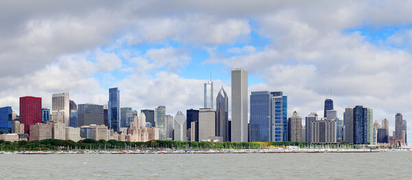 Chicago skyline panorama with skyscrapers over Lake Michigan with cloudy blue sky.