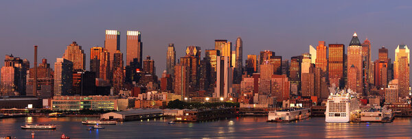 Urban city skyline. New York City Manhattan skyline panorama at sunset with Times Square and skyscrapers with reflection over Hudson river.