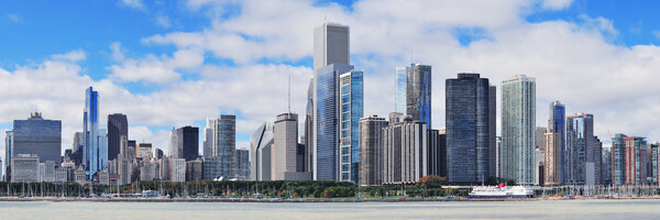 Chicago city urban skyline panorama with skyscrapers over Lake Michigan with cloudy blue sky.
