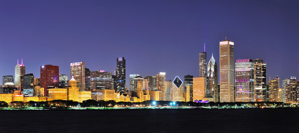Chicago city downtown urban skyline panorama at dusk with skyscrapers over Lake Michigan with clear blue sky.
