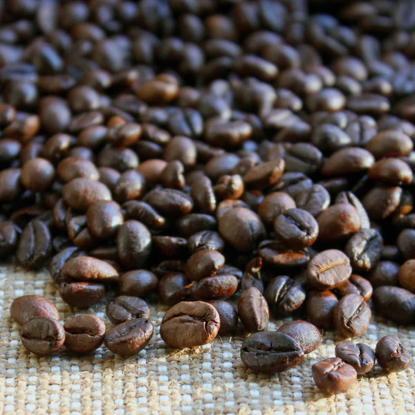 Coffee beans on brown canvas — Stock Photo, Image