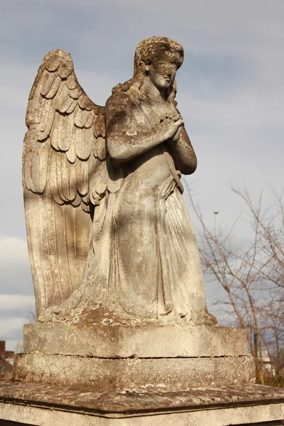 Mavi bir gökyüzü üzerinde dua eden bir melek figürü — Stok fotoğraf