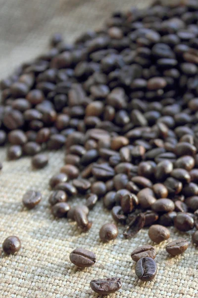 Coffee beans on brown canvas — Stock Photo, Image