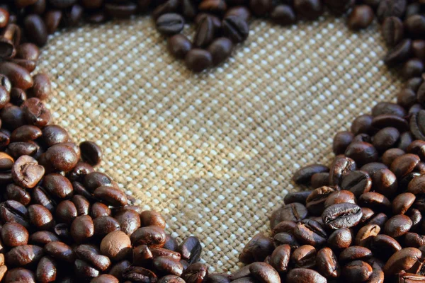 Кофейные зерна на коричневом холсте — стоковое фото