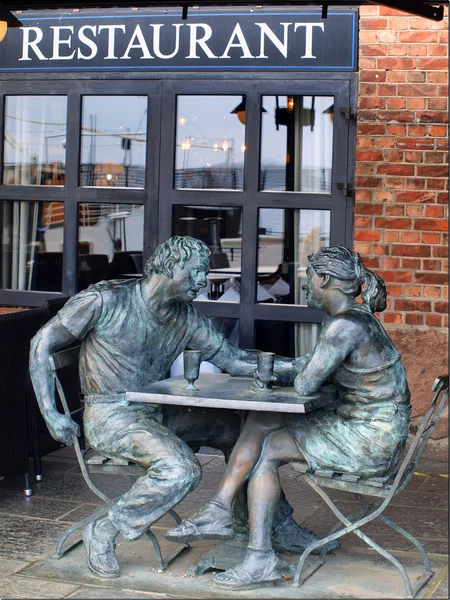 Stock image A couple as guests in the restaurant, bronze statue