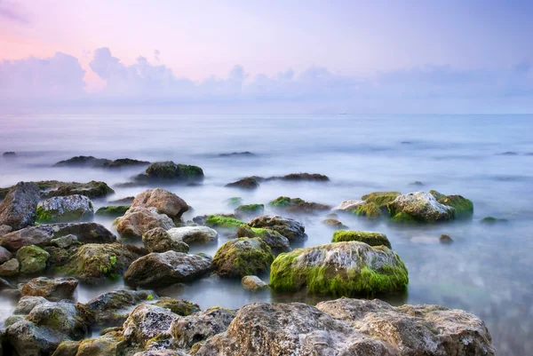 Gün batımında güzel kayalık deniz plaj — Stok fotoğraf