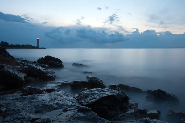 Нічний морський пейзаж з маяком і примхливим небом — стокове фото