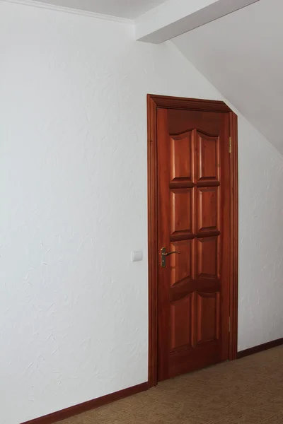La porta in legno nella stanza con soffitti spioventi — Foto Stock