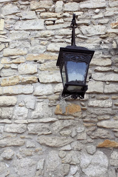 Lanterna de ferro forjado na parede de pedra — Fotografia de Stock