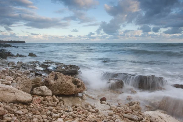 Gün batımında güzel kayalık deniz plaj — Stok fotoğraf