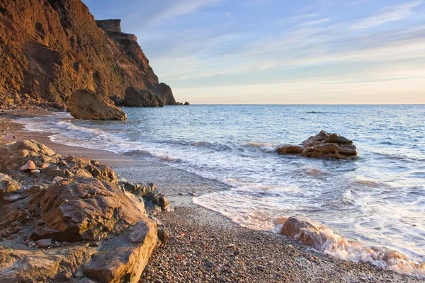 stock image A beautiful sea beach with stones reflect sunlight at sunset