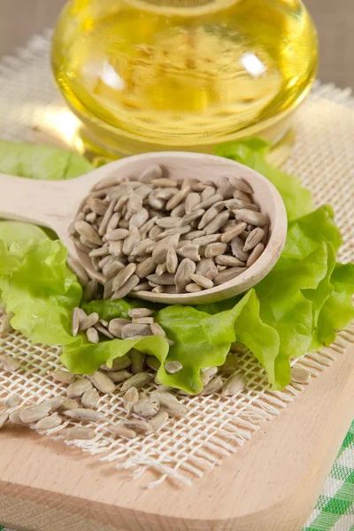 Sunflower oil and seeds on sacking — Stock Photo, Image