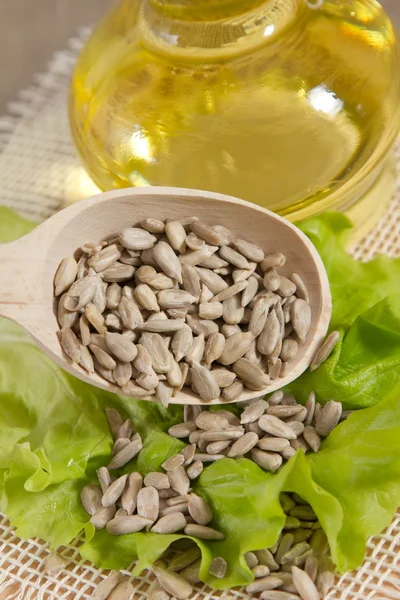 Sunflower oil and seeds on sacking — Stock Photo, Image
