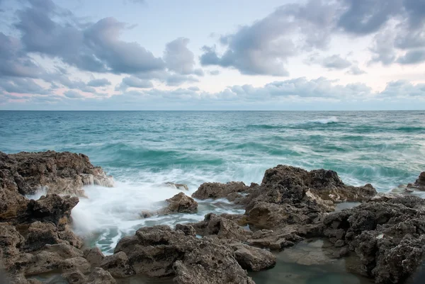 Hermosa playa de mar rocoso al atardecer — Foto de Stock