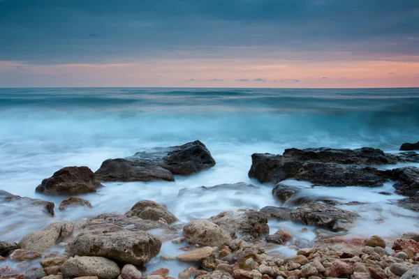 Vackra steniga stranden vid solnedgången — Stockfoto
