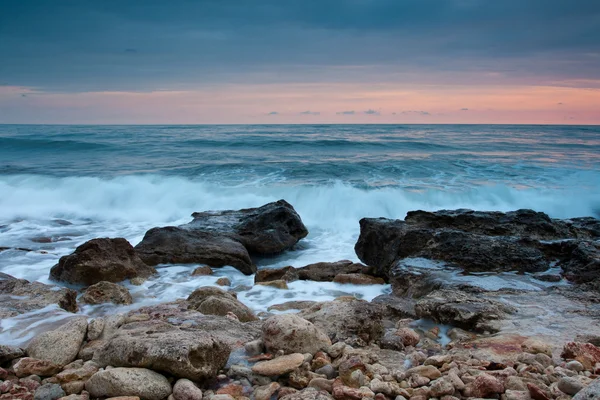 日没の美しい岩の海ビーチ — ストック写真