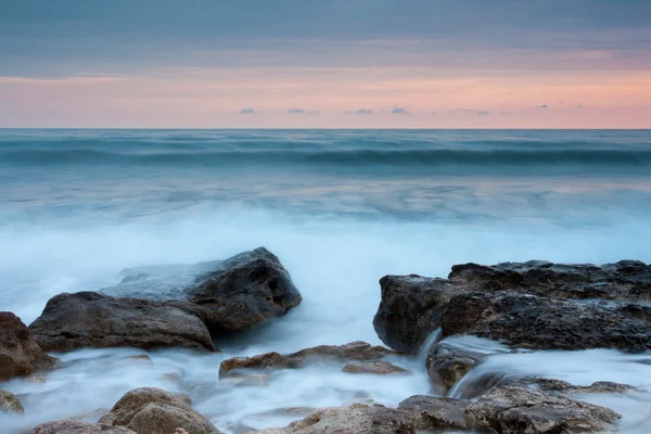 Krásné kamenné moře pláž při západu slunce — Stock fotografie
