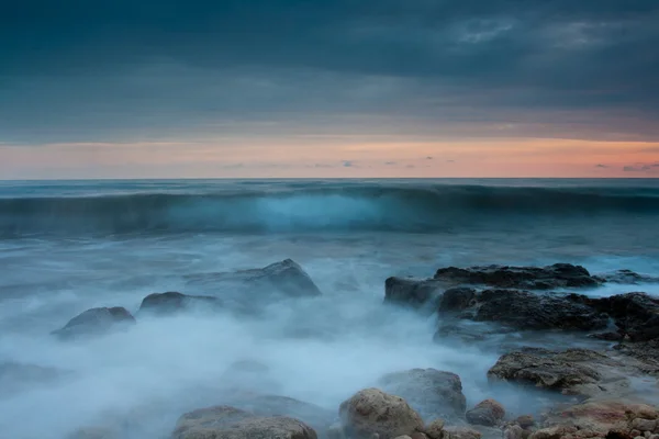 日没の美しい岩の海ビーチ — ストック写真