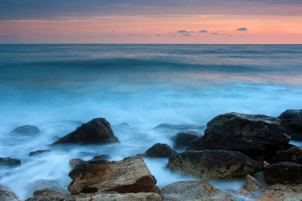 Bela praia de mar rochoso ao pôr do sol — Fotografia de Stock