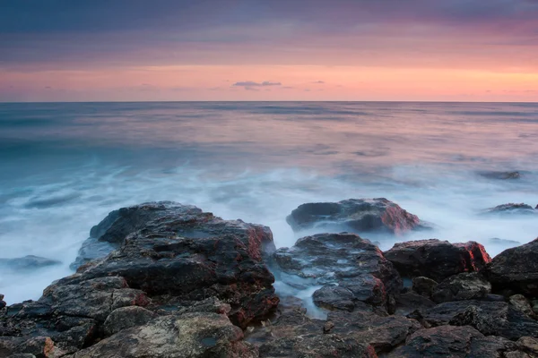 Beautiful rocky sea beach at the sunset — Stock Photo, Image