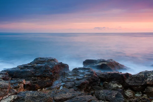Vackra steniga stranden vid solnedgången — Stockfoto